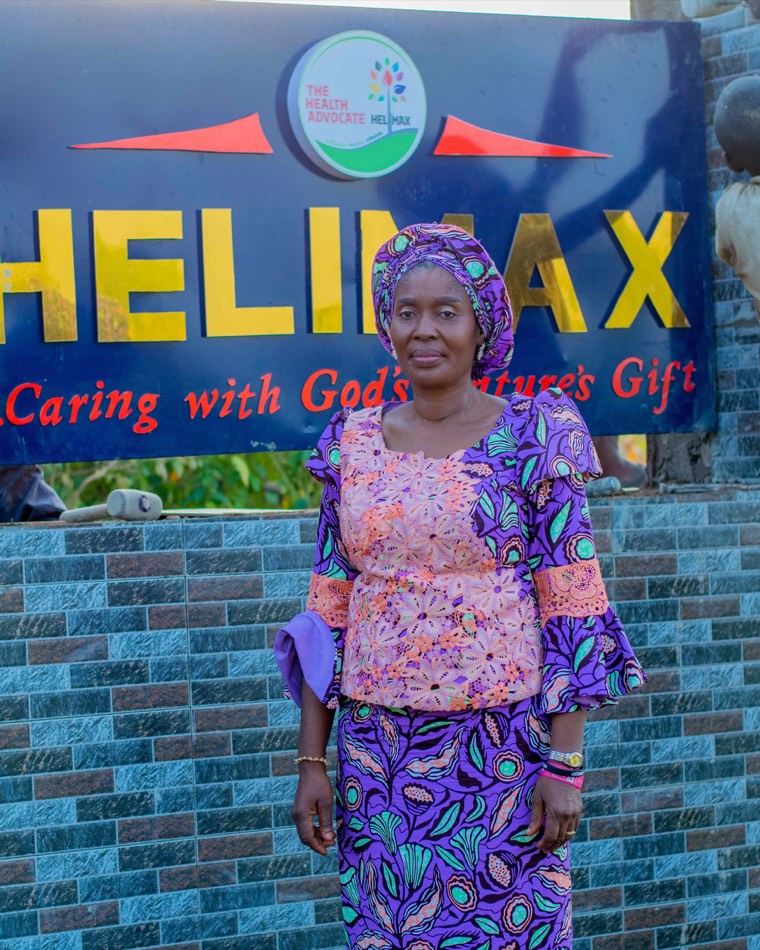 Mrs. Olisa in front of the Helimax signboard